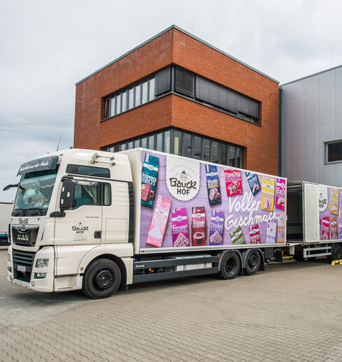 LKW mit dem Aufdruck von Bauck Produkten vor dem Bauck Gebäude