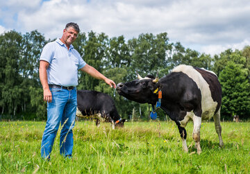 Ralf Weber mit einer Kuh auf einem Feld in Amelinghausen